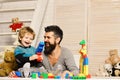 Boy and bearded man play together on wooden wall background Royalty Free Stock Photo