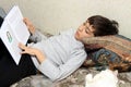 Boy on bed with cat, reading book