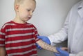 An allergist doctor makes a skin test for allergies. The boy is being examined in the laboratory, waiting for a reaction to