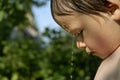 Boy beneath a jet of water in the garden Royalty Free Stock Photo