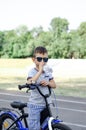 Boy with bicycle drinks bottled water