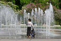 A boy with a bicycle looking at the dry fountain in Lilac garden in Moscow