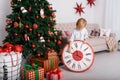 Boy with a big clock in Christmas tree Royalty Free Stock Photo