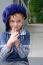 I like pranks, little boy with big violet cap looks around to see who he can fool Royalty Free Stock Photo