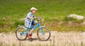 Boy with bike on a country road through meadow Royalty Free Stock Photo