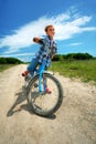 Boy with bike on a country road through meadow Royalty Free Stock Photo