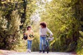 Boy With Bike And Girl With Skateboard Walking Along Country Road Together Royalty Free Stock Photo