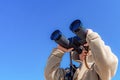A boy with binoculars on a background of blue sky looks up Royalty Free Stock Photo