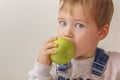 Boy bites a green apple Royalty Free Stock Photo