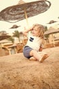 Boy with blond hair have fun on sand Royalty Free Stock Photo