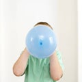 Boy blowing balloon. Conceptual image shot Royalty Free Stock Photo