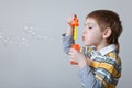 Boy blowing bubbles over grey Royalty Free Stock Photo