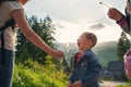 Boy blowing dandelion seeds in outdoor, mother help him Royalty Free Stock Photo