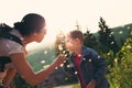 Boy blowing dandelion seeds in outdoor, mother help him Royalty Free Stock Photo