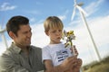 Boy Blowing Toy Windmill With Father