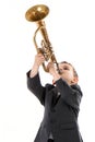 Boy blowing into a trumpet against white background Royalty Free Stock Photo