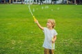 A boy blows bubbles against the grass Royalty Free Stock Photo