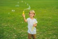 A boy blows bubbles against the grass Royalty Free Stock Photo