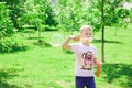 The boy blows bubbles in the park. Royalty Free Stock Photo