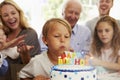 Boy Blows Out Birthday Cake Candles At Family Party Royalty Free Stock Photo