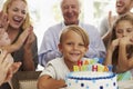 Boy Blows Out Birthday Cake Candles At Family Party Royalty Free Stock Photo