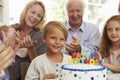 Boy Blows Out Birthday Cake Candles At Family Party Royalty Free Stock Photo