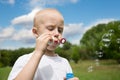 Boy blows soap bubbles in the park Royalty Free Stock Photo