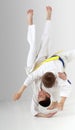 Boy with a blue belt throws boy with yellow belt