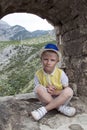 boy in a blue hat sitting in the observation window of the ancie