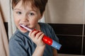 The boy brushes his teeth with a brush at the washbasin and smiles and looks into the lens. Portrait close up Royalty Free Stock Photo