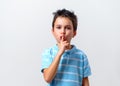 A boy in a blue T-shirt calls for a gesture to shut up. Keep quiet Royalty Free Stock Photo