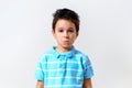 A boy in a blue T-shirt looks sadly and surprised at the camera Royalty Free Stock Photo