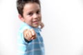 A boy in a blue T-shirt shows his fist to the camera. Focus on the fist Royalty Free Stock Photo
