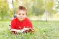 Boy with book laying on grass Royalty Free Stock Photo