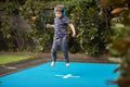 Boy bouncing on the trampoline wearing headphones Royalty Free Stock Photo