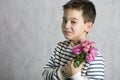 A boy with a bouquet of small pink roses in his hands. concept greetings for mother`s day, Royalty Free Stock Photo