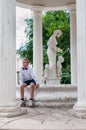 Boy in bow tie, sitting on the edge of the fountain in the old rotunda