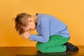 The boy bowed in prayer before God. The child is kneeling in the prayer of repentance before the Supreme Creator Royalty Free Stock Photo