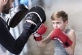 Boy boxer practicing punches with coach