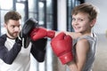 Boy boxer practicing punches with coach