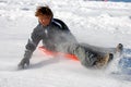 Boy Braking the Sled While Sledding Down the Hill