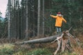 Boy in bright yellow parka puffer jacket walks in pine forest