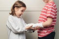 Boy broken arm, girl is in shock. Child girl holding his brother\'s broken arm. Boy holds hand bent broken arm cast Royalty Free Stock Photo