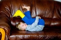 Boy with broken leg in cast lying on couch.