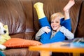 Boy with broken leg in cast sitting on couch.