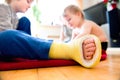 Boy with broken leg with his brother playing. Royalty Free Stock Photo