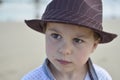 Boy with a brown hat looking very serious