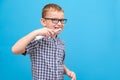 the boy is brushing his teeth. A small child with a toothbrush on a blue background