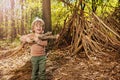 Boy with brushwood pile in the forest build hut of branches Royalty Free Stock Photo