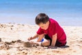 Boy building a sand castle on the beach Royalty Free Stock Photo